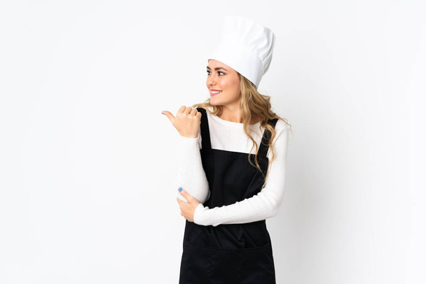 Jonge Braziliaanse chef-kok vrouw geïsoleerd op witte achtergrond wijzend naar de zijkant om een product te presenteren - Foto, afbeelding