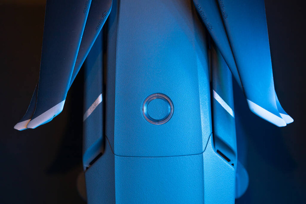 Top view of the drone body, power button with charge indicator, battery inserted into the quadcopter, drone propellers. In blue, close-up - Fotoğraf, Görsel