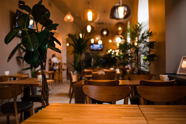 Beautiful interior restaurant with wooden tables and chairs. interior of the restaurant cafe table close-up, Soft focus. Shallow DOF - Fotó, kép