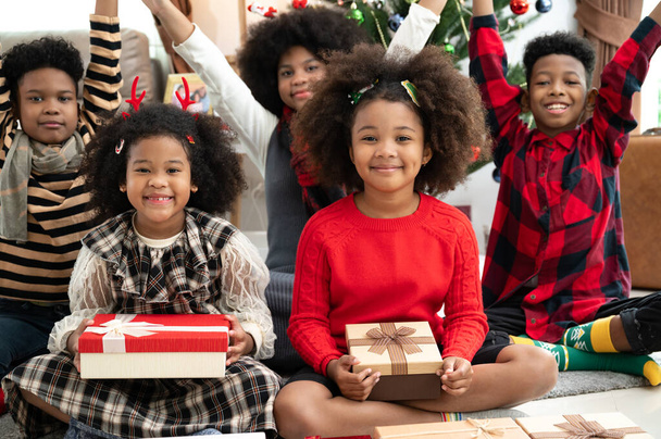 Joyeux afro enfant fille dans une chambre avec boîte cadeau et décorations de Noël - Photo, image