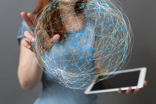A woman tapping on 3D rendered network sphere while holding a tablet - Valokuva, kuva