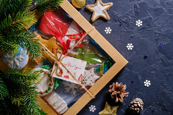 Regalo de Navidad con pan de jengibre sobre fondo azul con ramas de abeto, bultos y decoración de primer plano - Foto, Imagen