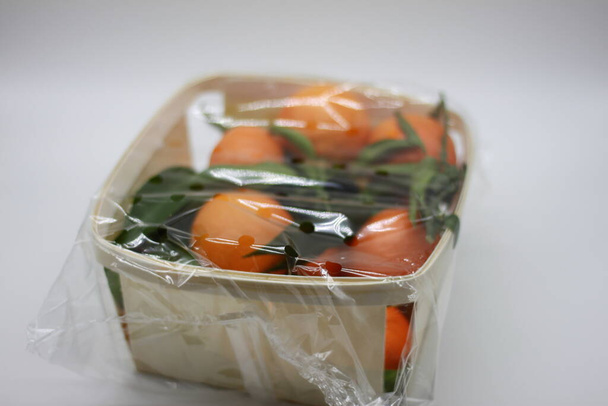 Mandarinen-Korb mit grünen Blättern - Foto, Bild