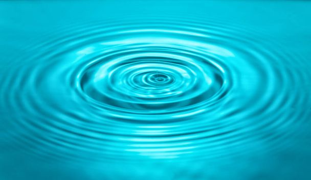 falling drops on the water surface, splash, ripples on the water, blue color - Photo, Image
