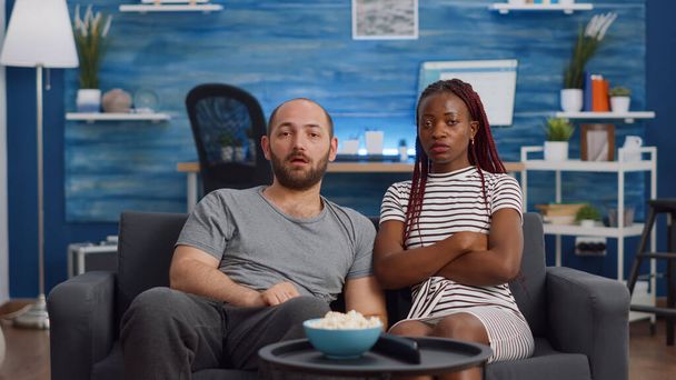 POV of interracial couple being shocked watching television - Photo, image