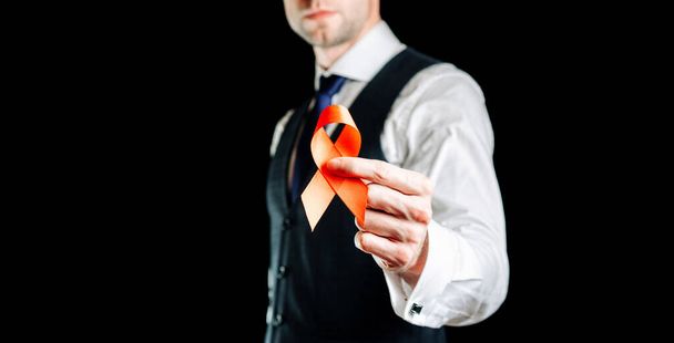 Hiv aids. Rode lint in hiv wereld dag geïsoleerd op donkere achtergrond. Man met bewustzijnshulpmiddelen en kankersymbool. Gezondheid, Medisch teken. kopieerruimte. - Foto, afbeelding