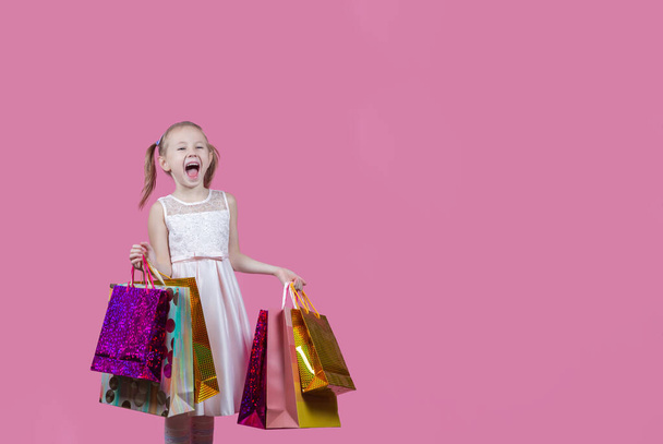 Portrait of positive caucasian girl have fun on free time holding colorful bags addicted shopper bargains over pink color background with copy space. - Foto, afbeelding