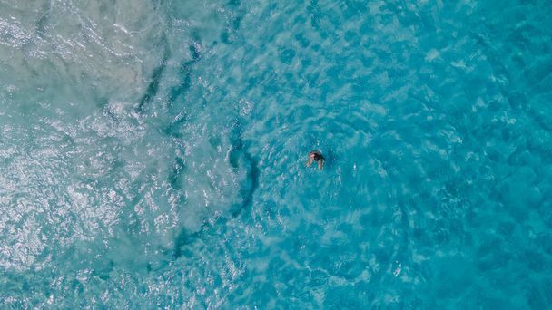 Un par de mujeres flotando en un océano azul claro. Vista aérea. Foto de alta calidad - Foto, Imagen