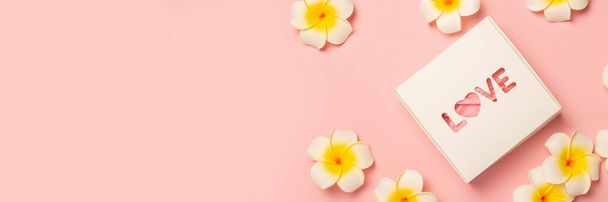 Gift box and flowers on a pastel pink background. Composition Valentine's Day. Flat lay, top view. Banner. - Photo, Image
