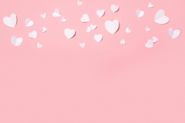 Valentin-napi papírból készült, szív alakú, rózsaszín háttérrel. A Valentin-nap összetétele. Zászlós. Lapos fekvésű, felülnézet. - Fotó, kép