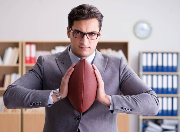 Biznesmen z amerykańskim futbolem w biurze - Zdjęcie, obraz