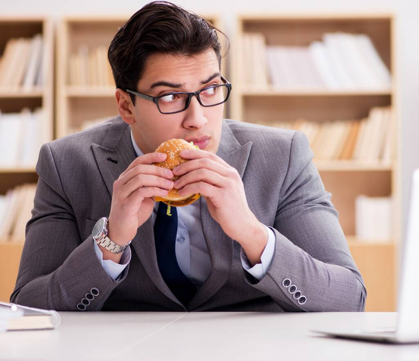 Hungry funny businessman eating junk food sandwich - Photo, Image