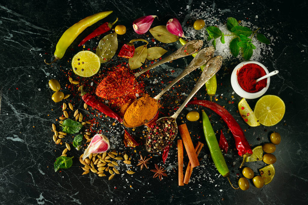 Many different spices and aromatic herbs on a dark table. View from above. - Фото, зображення