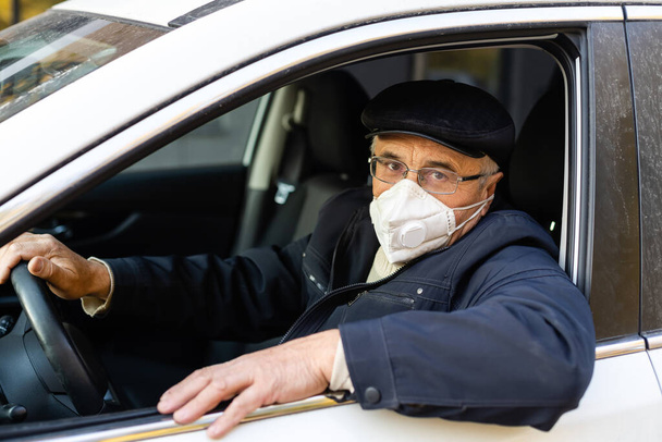 Starší muž s obličejovou maskou vchází do svého auta doma. - Fotografie, Obrázek