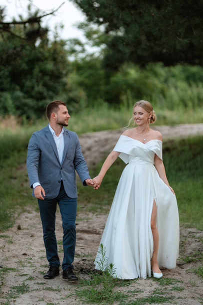bride and groom on a walk in the woods - Foto, Imagen