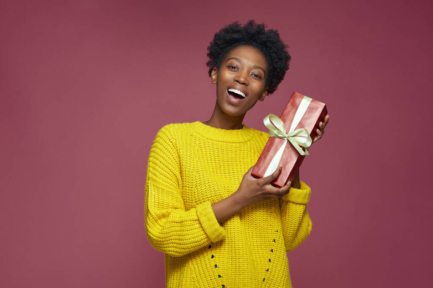 Iloinen afrikkalainen amerikkalainen tyttö, jolla oli lahjapakkaus, syntymäpäivälahja. Joulun myynti ja loma hyväntekeväisyyden käsite  - Valokuva, kuva