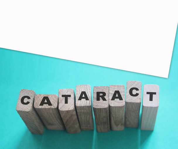 Cataract word made with building blocks on light cyan. Eye healthcare concept. - 写真・画像
