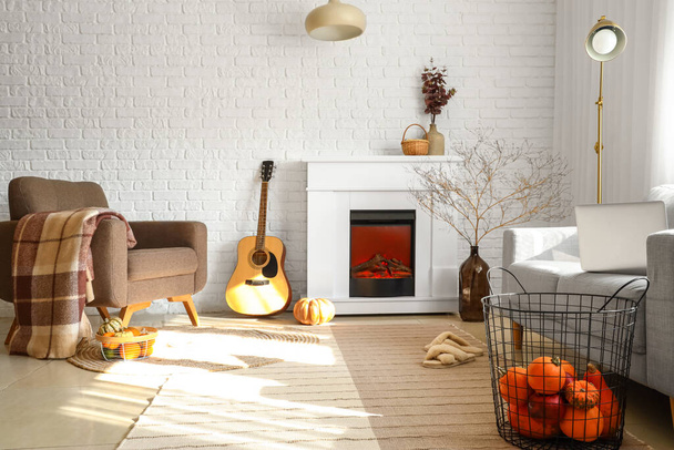 暖炉と秋の装飾付きのリビングルームの居心地の良いインテリア - 写真・画像