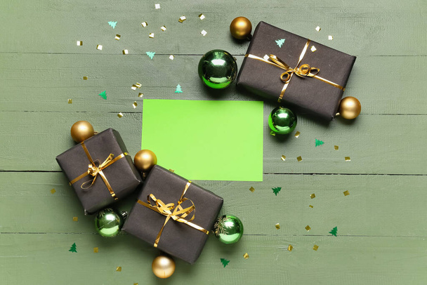 Carta verde vuota, decorazioni natalizie e scatole regalo su sfondo di legno a colori - Foto, immagini
