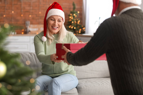 Зрелый мужчина приветствует жену в канун Рождества - Фото, изображение