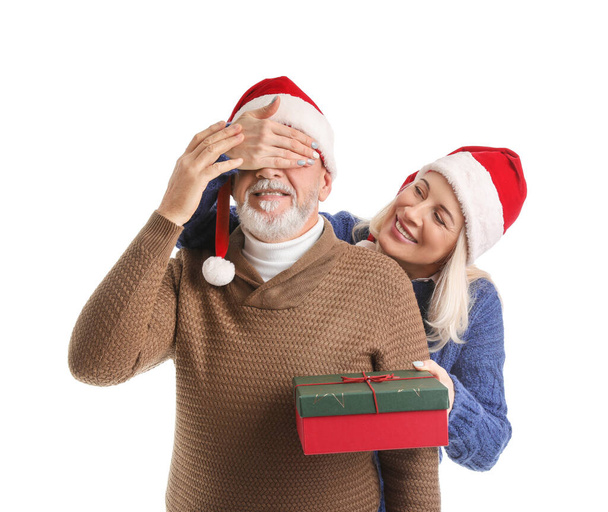 Feliz mujer madura saludando a su marido en la víspera de Navidad sobre fondo blanco - Foto, imagen