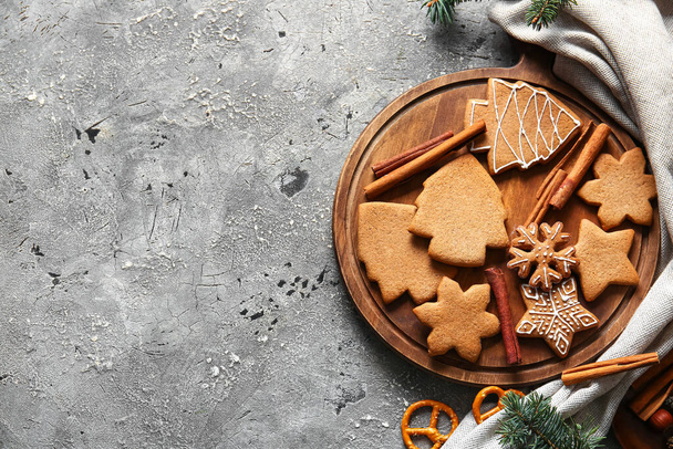 Tablero de madera con galletas dulces de jengibre de Navidad sobre fondo gris - Foto, imagen