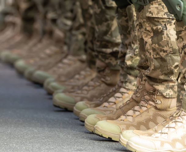 Askerlerin bacakları ayak bileği çizmeleri ve kamuflaj pantolonu içinde.. - Fotoğraf, Görsel