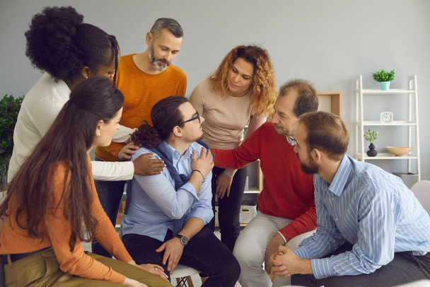 Young patient accepting help from diverse men and women in a group therapy session - Φωτογραφία, εικόνα