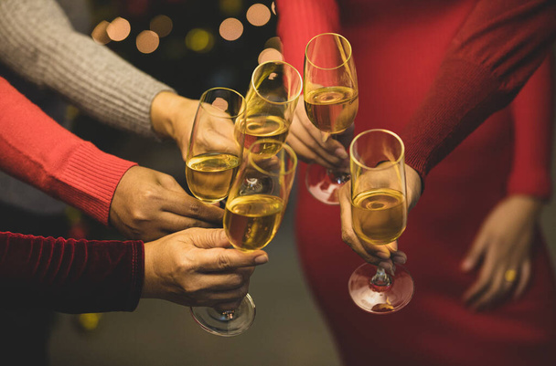 Women on sweater clink glass of beverage together to start holiday event of jolly drink at gala party for celebrating group success. cheerful relationship. Add some noise to fit vintage-style image. - Photo, Image