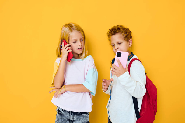 niños de la escuela mirando en un teléfono inteligente y jugando juegos - Foto, Imagen