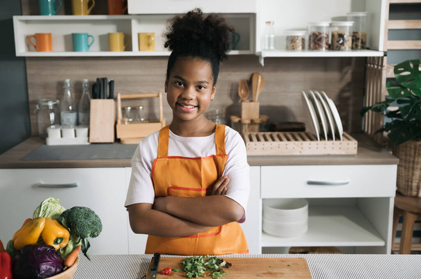 Onnellinen lapsi musta iho salaatti lautasella keittiössä - Valokuva, kuva