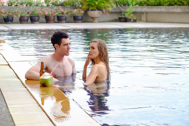 Портретная пара в любви, сексуальное бикини у бассейна весело провести время в бассейне, счастливая жизнь в летний сезон - Фото, изображение