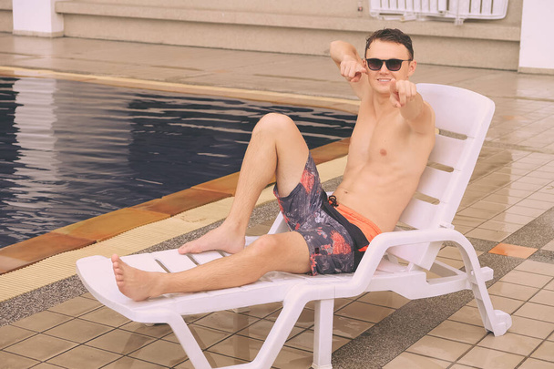 ritratto sexy caucasico bello uomo vicino a bordo piscina - Foto, immagini