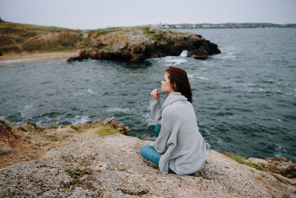 donna seduta sulla costa maglione paesaggio femminile rilassante - Foto, immagini