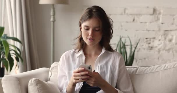 Young woman holds cellphone read good news feels overjoyed - Felvétel, videó