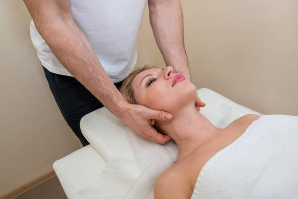 massagem no pescoço no salão de spa para a menina. conceito de massagem de bem-estar. Massagem massagista masculina menina loira - Foto, Imagem