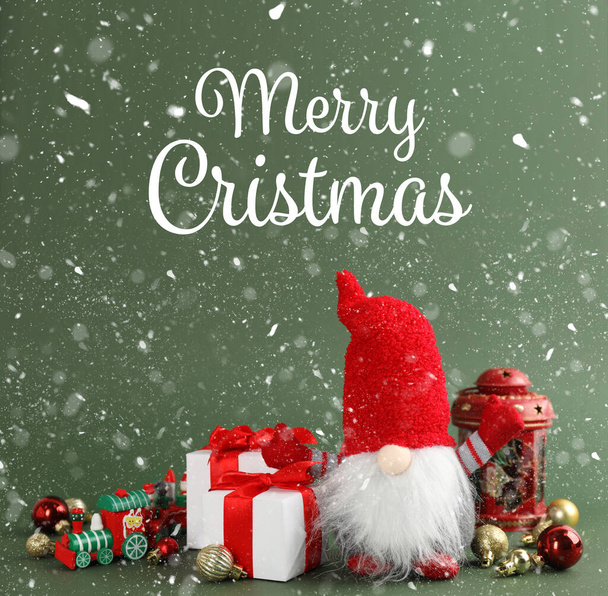 Merry Christmas! Cute gnome, gift boxes and festive decor on green background - Foto, imagen