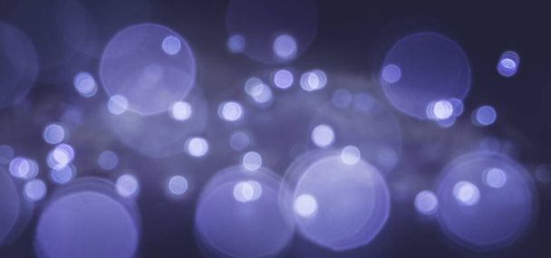 Μπλε και μωβ εορταστικό φόντο με φώτα αποεστιασμένα διαφόρων διαμέτρων. - Φωτογραφία, εικόνα