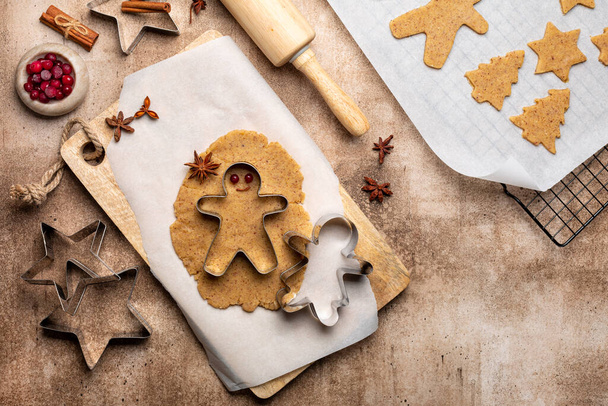 Cooking Christmas cookies, gingerbread man with cutter. Made with hazelnut butter. Christmas and New Year traditions concept, view from above, copy space. - Foto, immagini