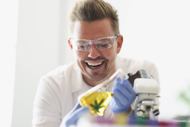 Hullu laboratoriotyöntekijä löytää marihuanauute öljyä laboratoriossa - Valokuva, kuva