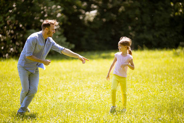 Padre persiguiendo a su linda hijita mientras juega en el parque - Foto, Imagen