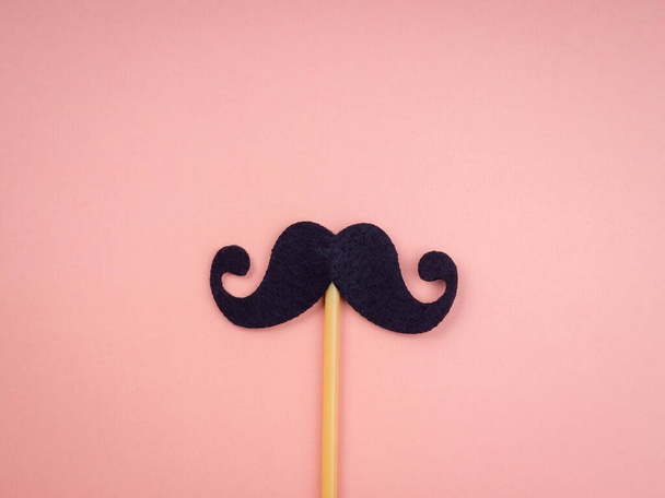 Mustache stick isolated on pink pastel background, minimal style. Happy fathers day, Movember concept.  - Fotoğraf, Görsel