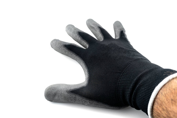 Czarna rękawica robocza na otwartej dłoni pokrytej lateksem w środku, odizolowana na białym tle, widoczna górna dłoń. - Zdjęcie, obraz