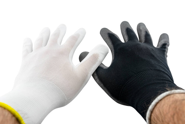 Białe i czarne rękawice robocze na otwartych dłoniach mężczyzny pokryte lateksem od wewnątrz, odizolowane na białym tle ze ścieżką wycinania, skrzyżowane dwoma kciukami. - Zdjęcie, obraz