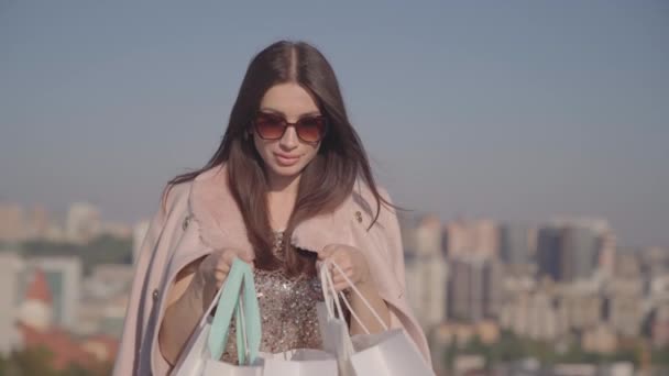 Shopaholic γυναίκα σοκαρισμένος ψάχνει σε τσάντα ψώνια εξωτερική - Πλάνα, βίντεο