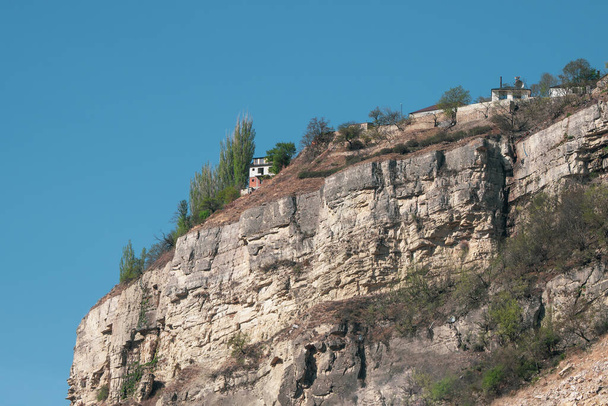 Дом на утесе. Одинокий дом на скале в Кавказских горах. Высокогорный город на скале.  - Фото, изображение