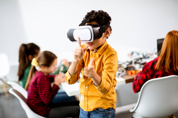 Roztomilý chlapeček v brýlích virtuální reality VR ve třídě robotiky - Fotografie, Obrázek