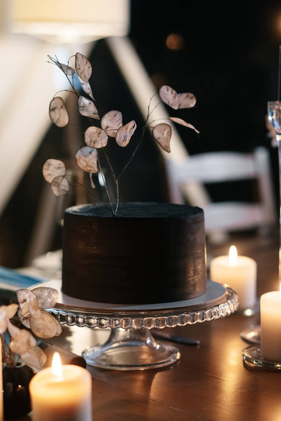 Minimalistic wedding cake on a serving table in lights - Fotoğraf, Görsel