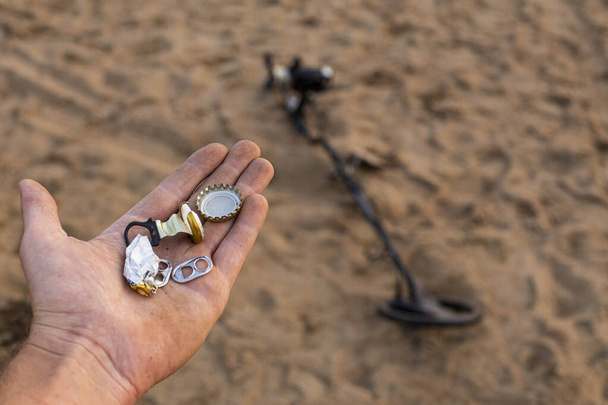 odpad nalezený na pláži s detektorem kovu, problém znečištění lidí na planetě - Fotografie, Obrázek