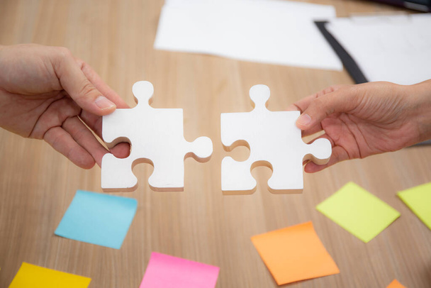 Hands of team young business and partner holding piece jigsaw for assembly is metaphor, teamwork symbol, bonding and harmony in team, friendship and marketing, business and communication concepts. - Photo, Image